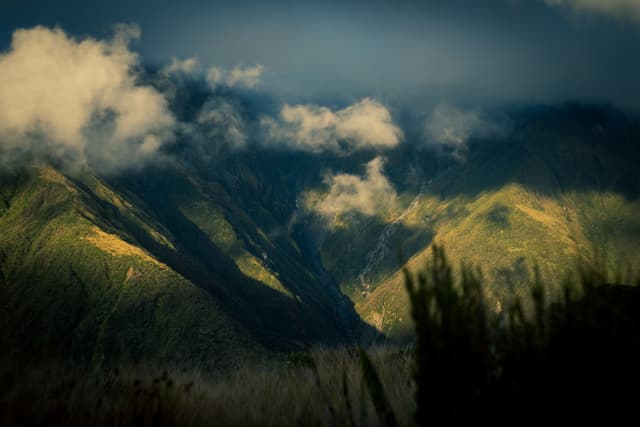 Mountains Clouds Sky Landscape Nature Green Blue Valley Hills Peaks Shadows Light Scenic Outdoors Rugged Terrain Mist Fog Vegetation Grass Sunlight Horizon Atmospheric Wilderness Remote Tranquil Majestic Serene Peaceful