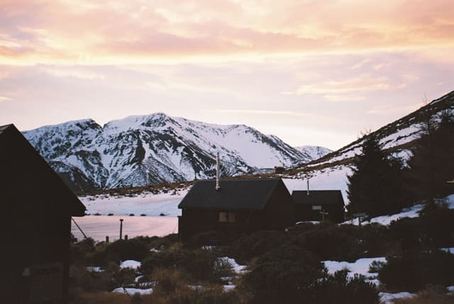 mountains snow cabin lake sunset sky clouds trees landscape winter nature outdoor scenic silhouette orange white brown black