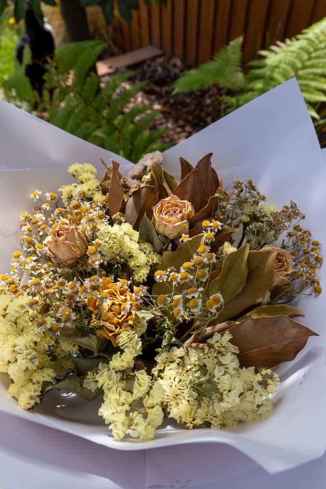 flowers bouquet roses leaves dried yellow brown white paper greenery background