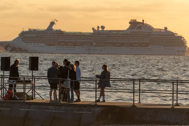 Sunset Ocean Cruise Ship People Group Railings Speakers Silhouette Water Sky Horizon Deck Vacation Travel Leisure Gathering Relaxation Scenic Seascape Evening Outdoors Golden Orange Blue Calm Peaceful Coastal Maritime Summer Adventure Journey