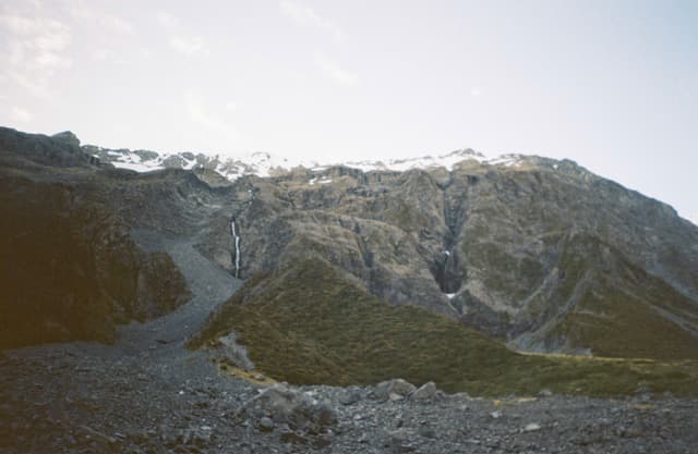 Mountain Landscape Rocks Sky Snow Green Valley Cliff Slope Ridge Hill Peak Summit Terrain Nature Outdoors Scenery Horizon Blue Rugged Wilderness Natural Formation Erosion Geological Earth Stone Craggy Majestic Remote