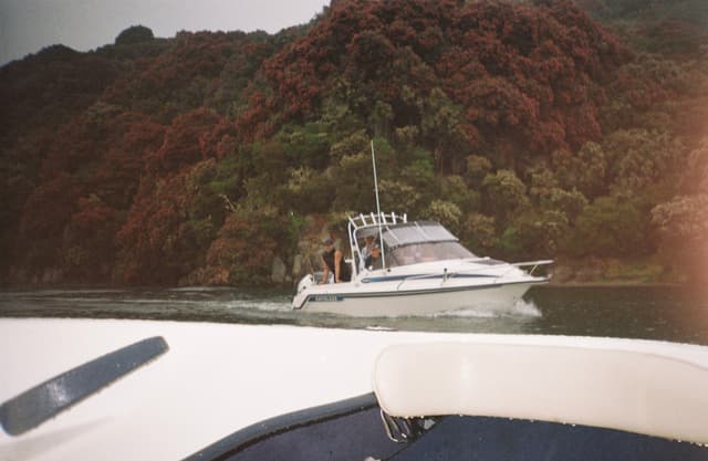 boat water trees forest mountain sky white blue green red nature outdoor landscape sailing vessel foliage hill lake river reflection travel scenery