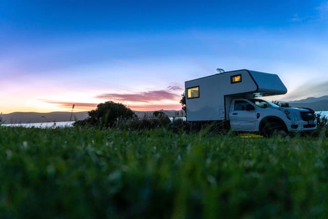 camper van vehicle grass sunset sky clouds landscape nature outdoor travel camping adventure road trip horizon blue green white silhouette twilight scenery relaxation exploration freedom tranquility