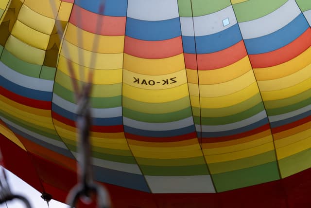 balloon hot air balloon stripes colorful pattern fabric ropes basket sky outdoor travel adventure primary color red blue yellow green multicolor air flight inflate vertical horizontal vibrant bright texture design transportation leisure activity festival tourism journey exploration equipment helium nylon canvas patchwork segment section panel airship aerostat