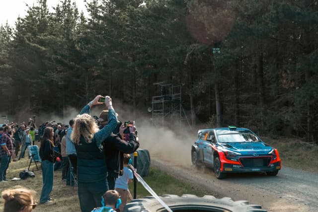 Rally Car Race Forest Spectators Dirt Road Trees Dust Blue Car Photography Event Action Motion Outdoors Daytime Racing Excitement Crowd Nature Sport Vehicle Speed Adventure Competition Landscape Pathway Greenery Enthusiasm Gathering