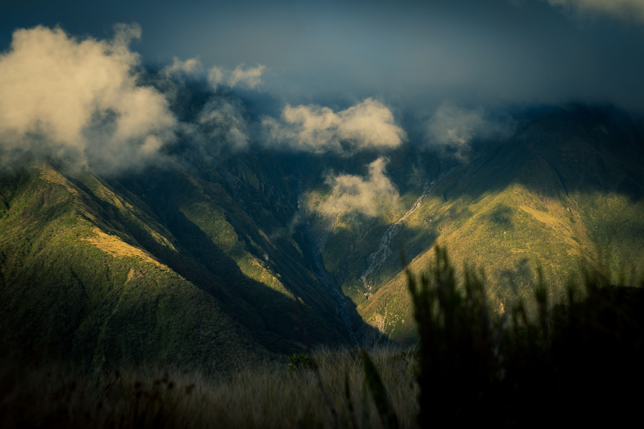 Mountains Clouds Sky Landscape Nature Green Blue Valley Hills Peaks Shadows Light Scenic Outdoors Rugged Terrain Mist Fog Vegetation Grass Sunlight Horizon Atmospheric Wilderness Remote Tranquil Majestic Serene Peaceful