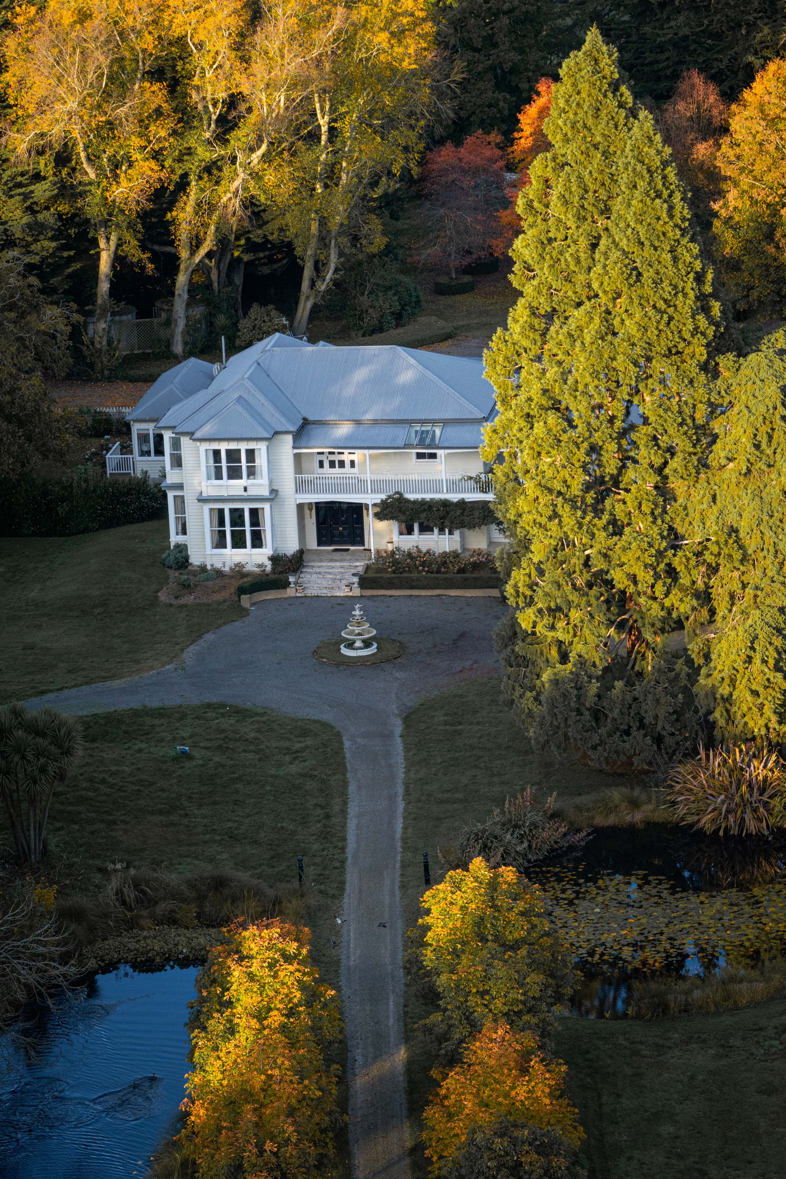house trees garden driveway fountain pond autumn leaves path lawn white green yellow blue sky forest shrubs bushes landscape architecture nature outdoor scenic