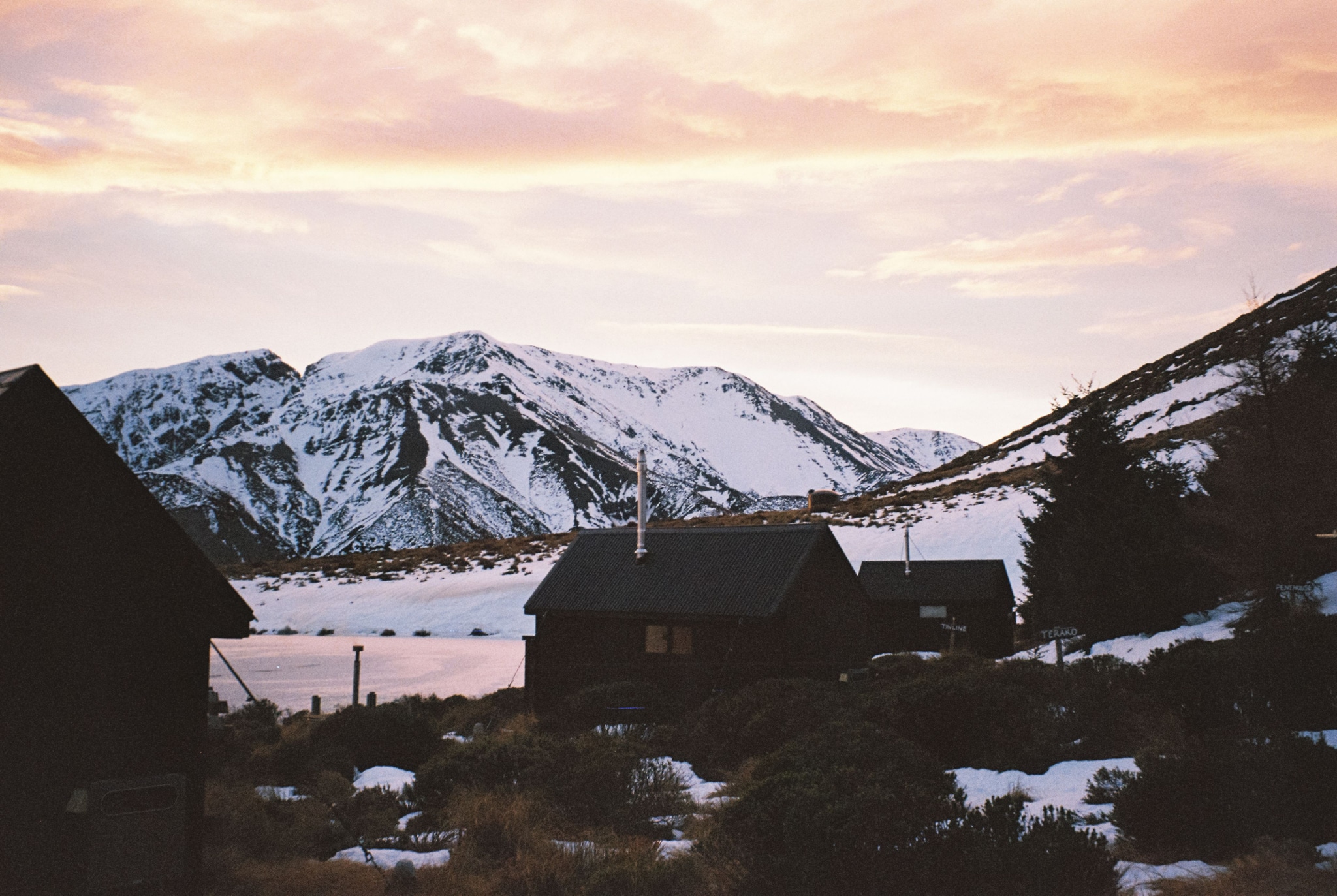 mountains snow cabin lake sunset sky clouds trees landscape winter nature outdoor scenic silhouette orange white brown black