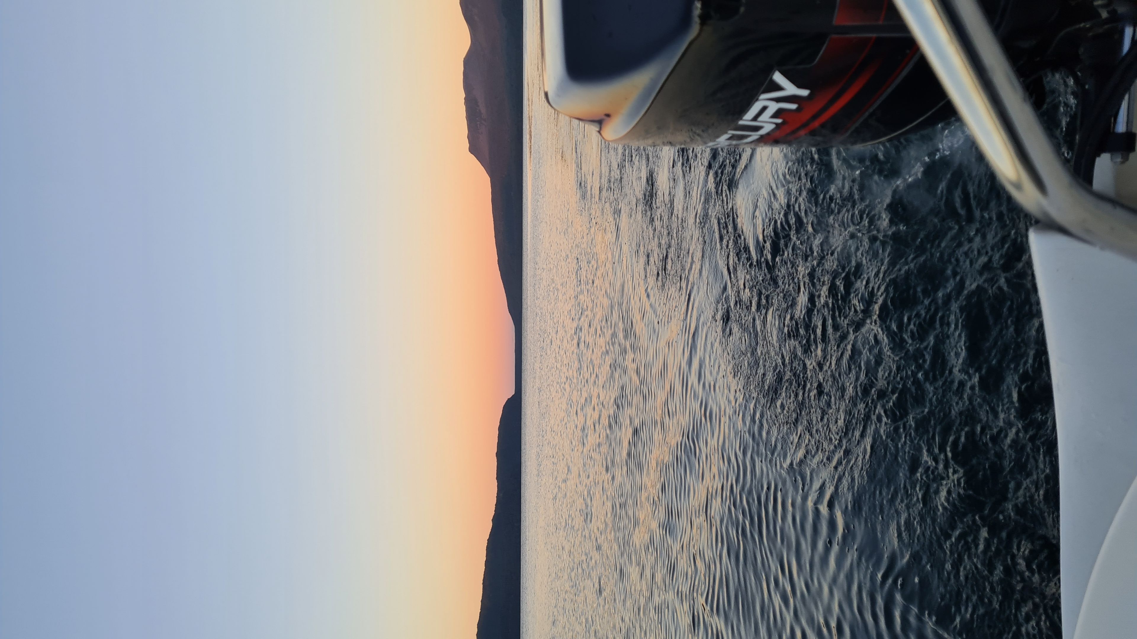 boat water lake sunset horizon mountains sky engine waves reflection orange blue black white landscape boating nature outdoor travel serene calm twilight dusk