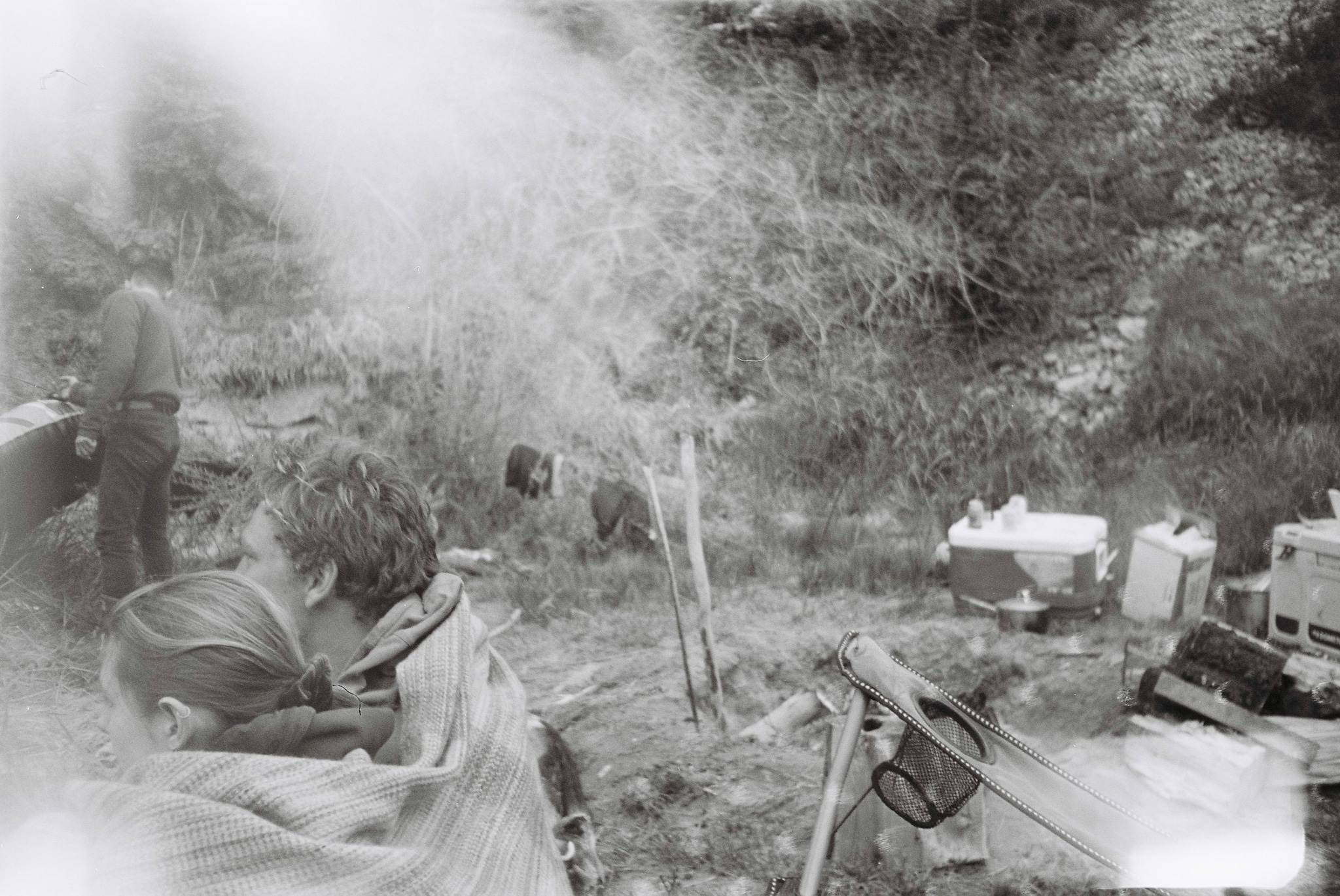 black white people trees grass camera tripod equipment outdoors nature forest camping blanket smoke vintage retro film photography