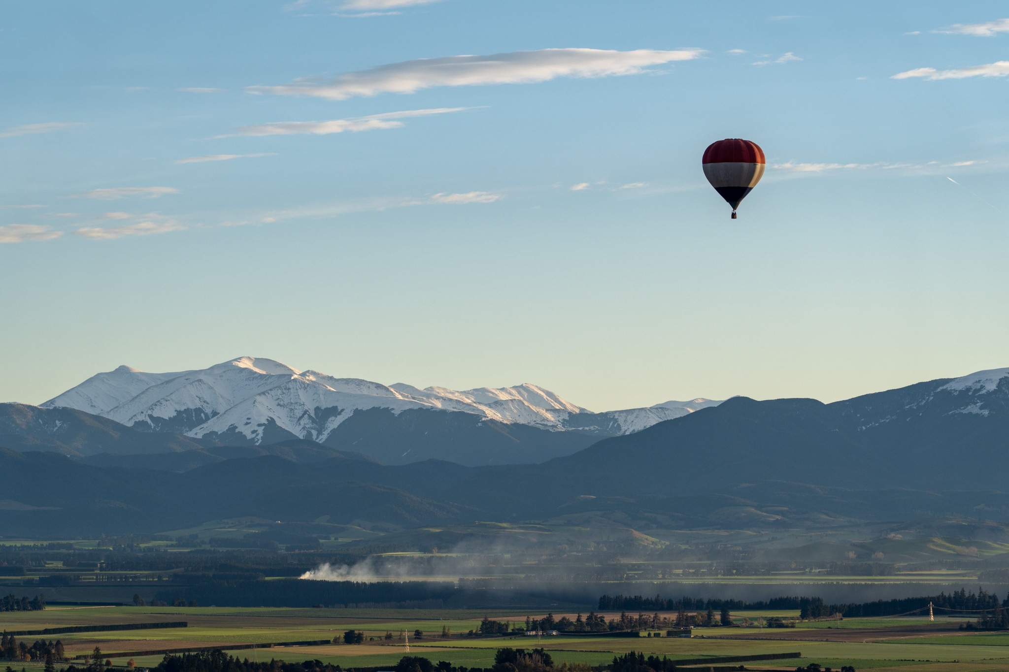 sky mountains hot air balloon landscape clouds snow fields horizon blue green red white scenery travel adventure nature outdoor panoramic peaceful serene