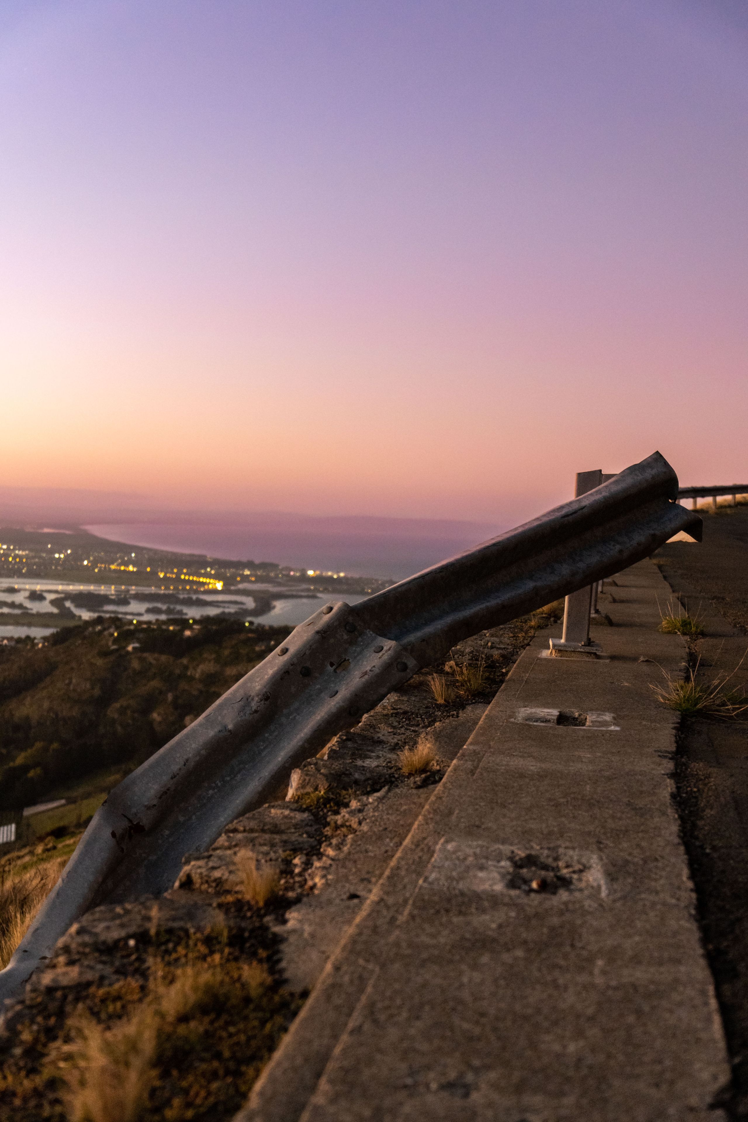 Sunset Sky Guardrail Road Concrete Hill Cityscape Lights Horizon Landscape Pink Purple Yellow Twilight Evening Outdoors Nature Scenic