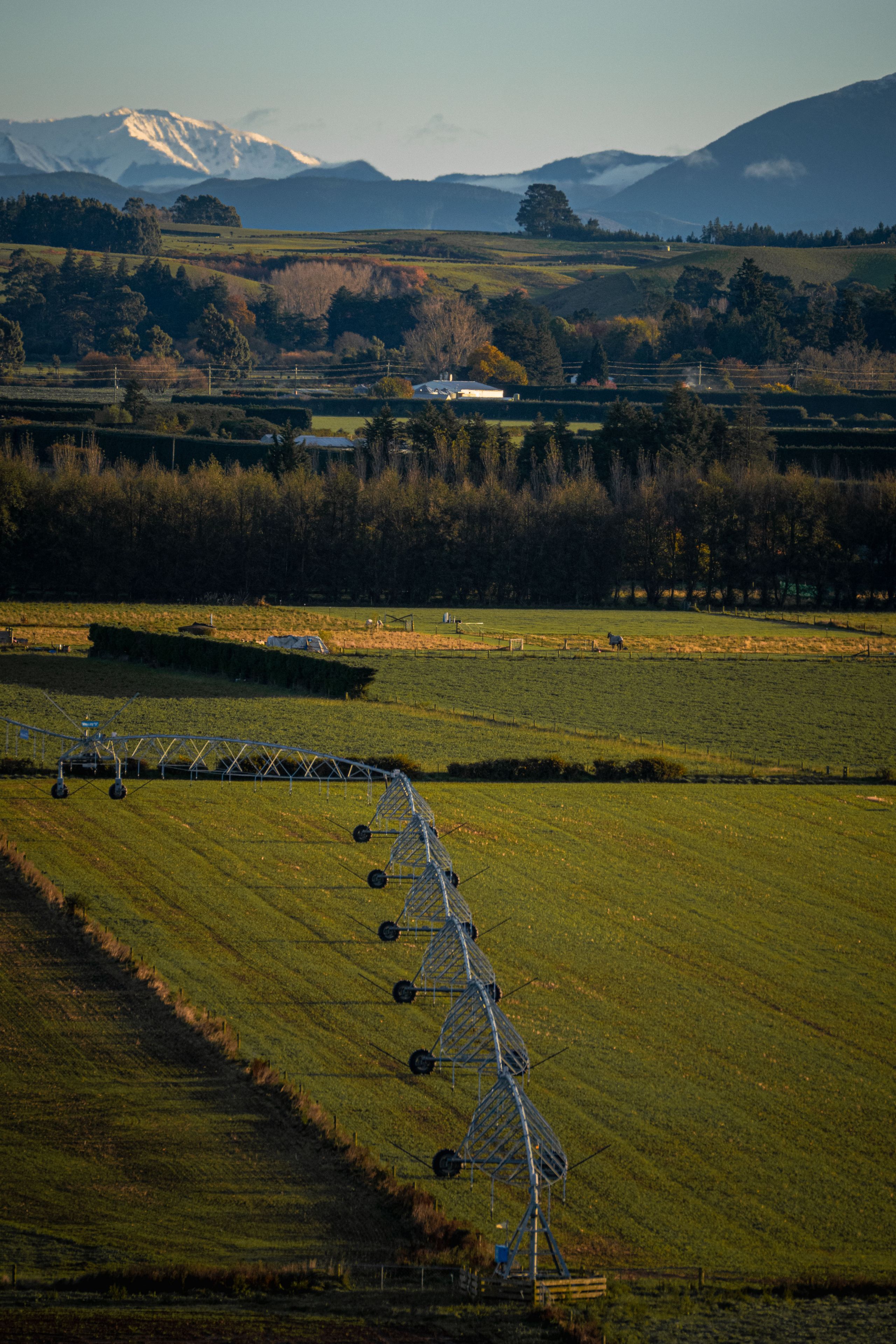 landscape field irrigation system mountains trees sky grass agriculture rural nature horizon greenery blue equipment farmland countryside hills scenery outdoors plains meadow pasture crops farming machinery