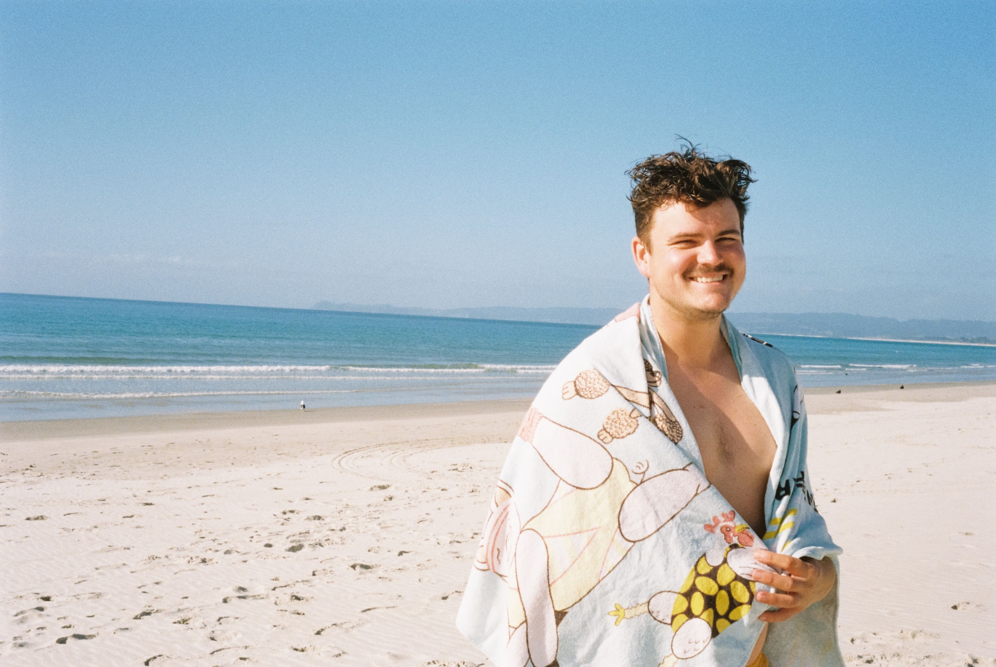 Beach Ocean Sand Towel Person Sky Blue Smiling Water Coastline Shoreline Seaside Relaxation Vacation Outdoors Sunny Daylight Horizon Waves Summer Leisure Nature Peaceful Calm Scenic Tranquil Fun Enjoyment Happiness
